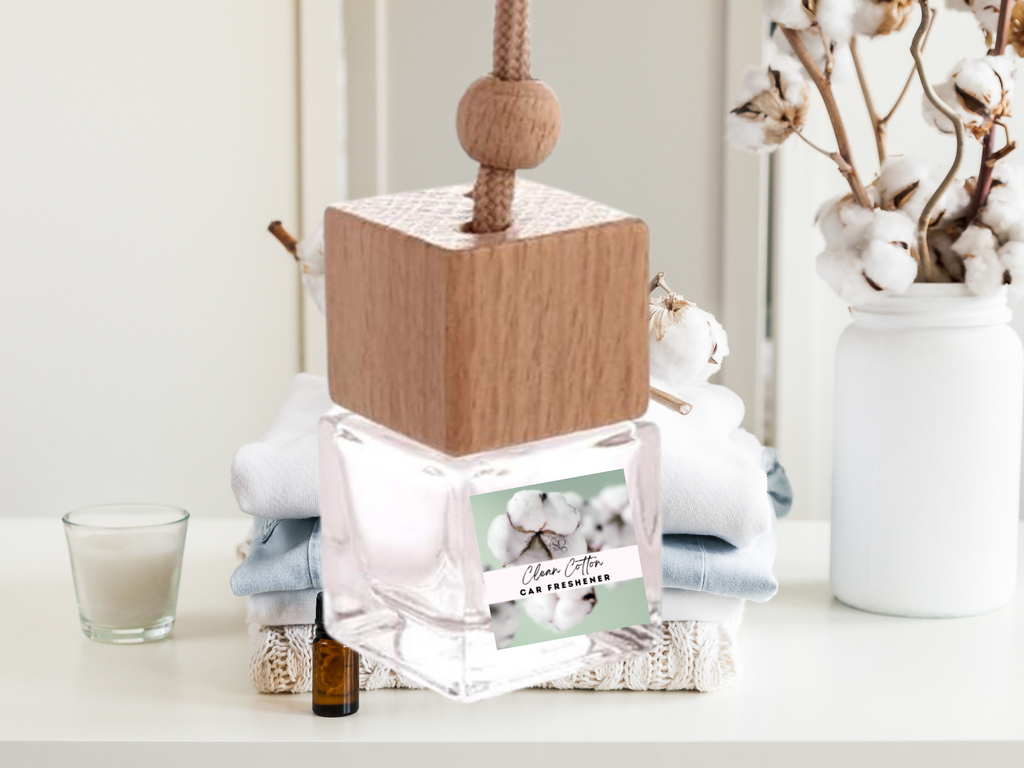 Hanging car freshener glass bottle with minimalist wooden cap and attached rope for continuous fragrance.