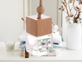 Hanging car freshener glass bottle with minimalist wooden cap and attached rope for continuous fragrance.