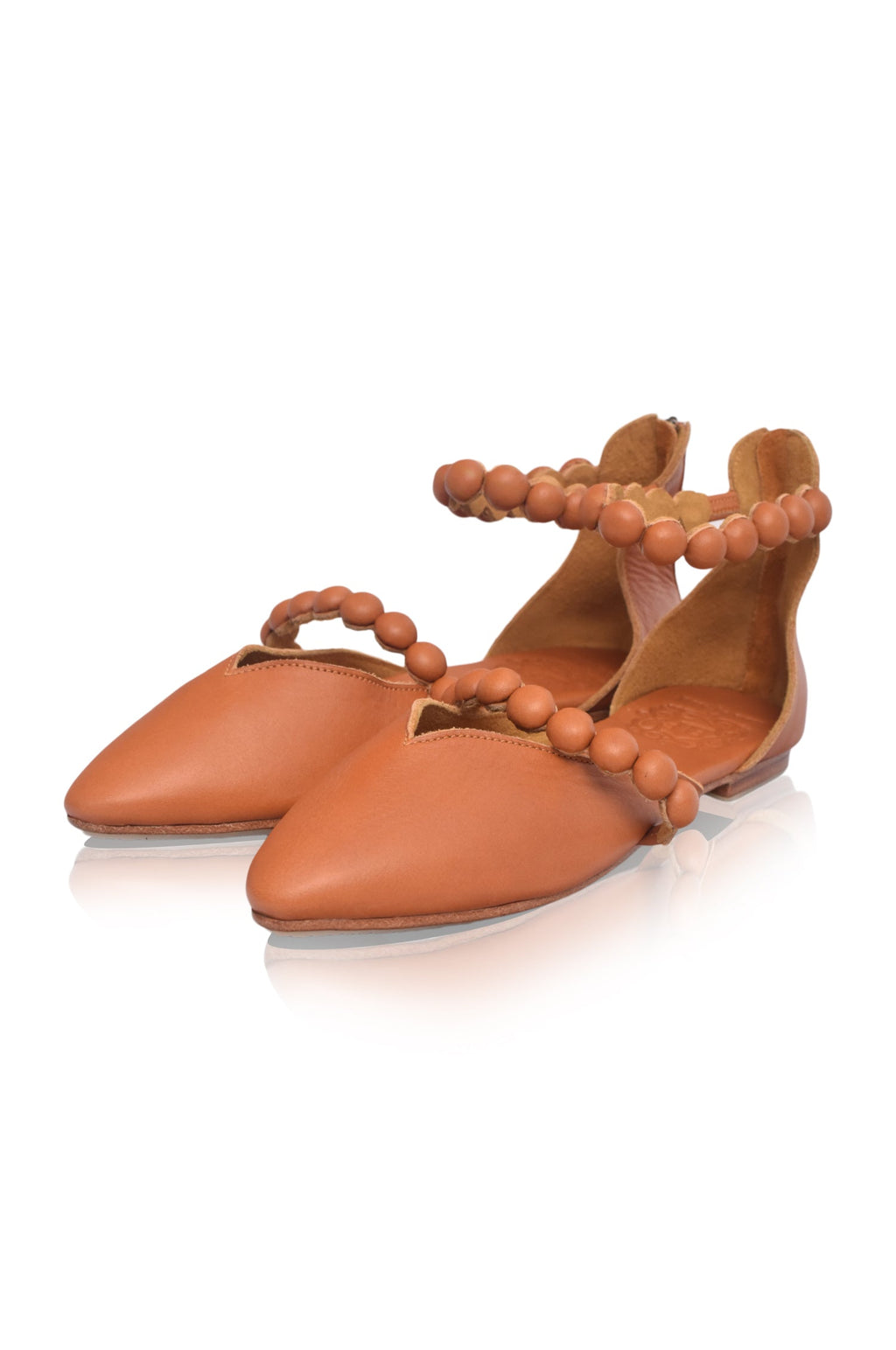 Tan leather ballet flats with pointy toe, wrapped buttons, and ankle strap details — view 4