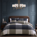 Navy and tan plaid five piece reversible comforter set with shams and decorative pillows.