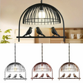 Industrial birdcage pendant light in vintage brass with black cable and round ceiling canopy