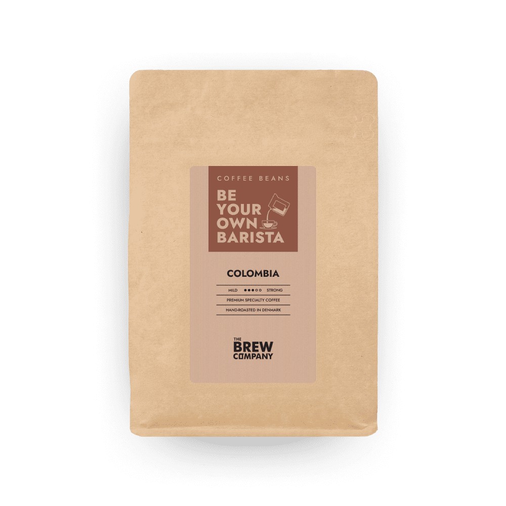 Freshly roasted Colombia Tolima whole coffee beans displayed in an eco-friendly kraft paper bag.