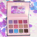 Open 12-color eyeshadow palette in a compact black case showing vibrant and neutral shades