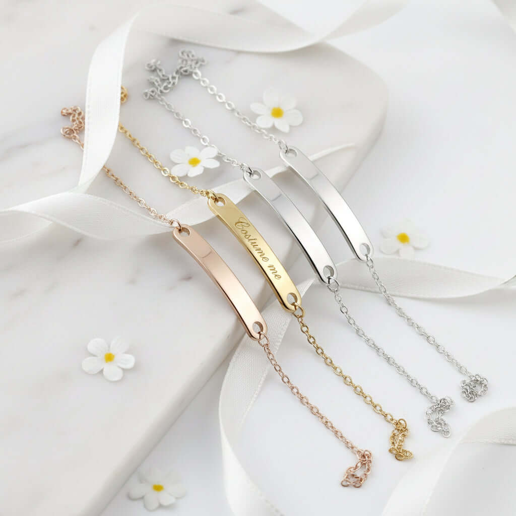 Custom engraved name bracelet in polished stainless steel showcasing personalized text on a delicate chain
