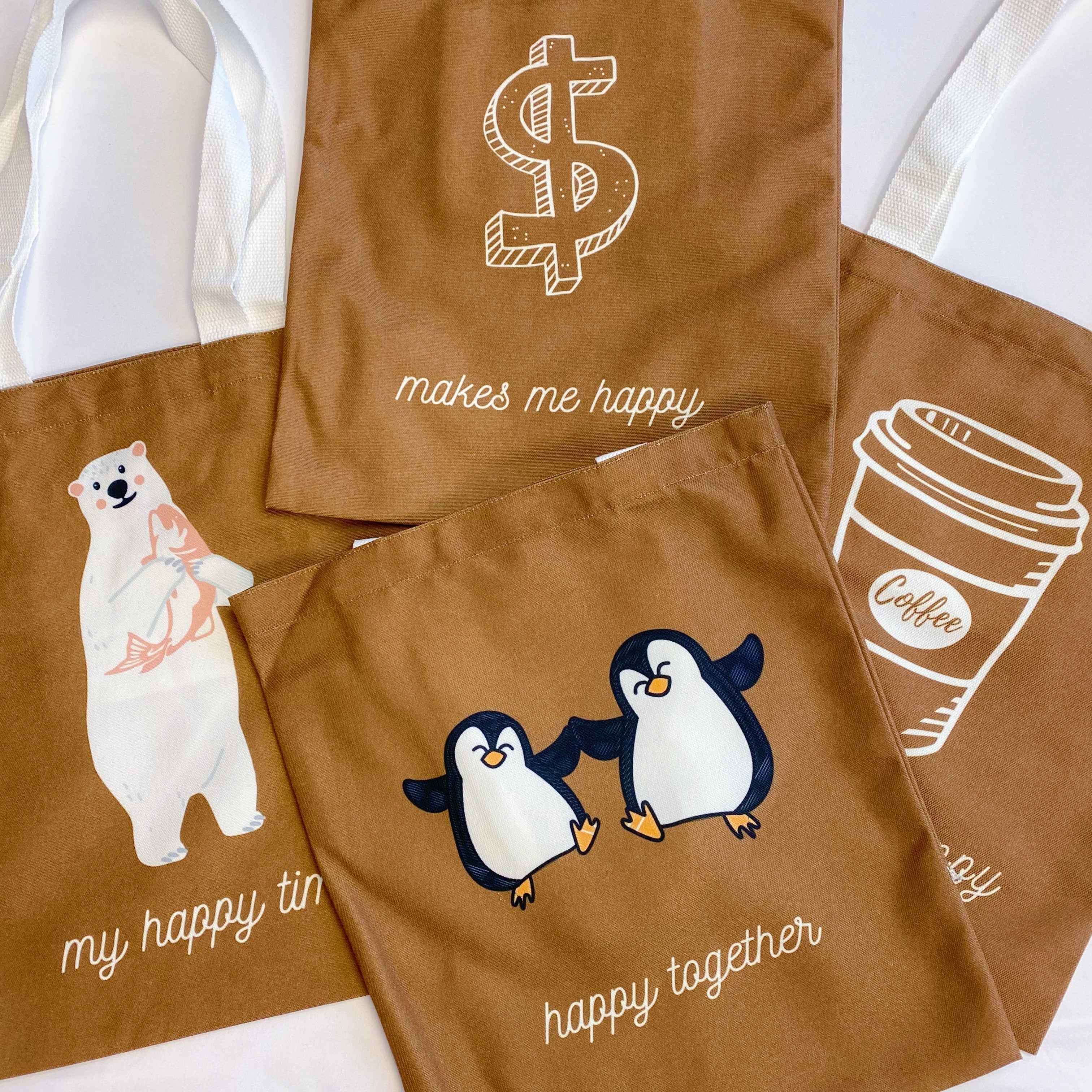 White canvas tote bag with graphic print and shoulder strap carrying books and a laptop — view 2