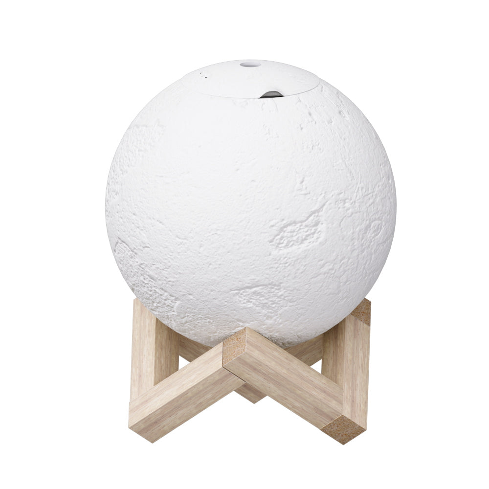 White LED moon lamp aroma diffuser resting on a wooden base with mist emitting from top