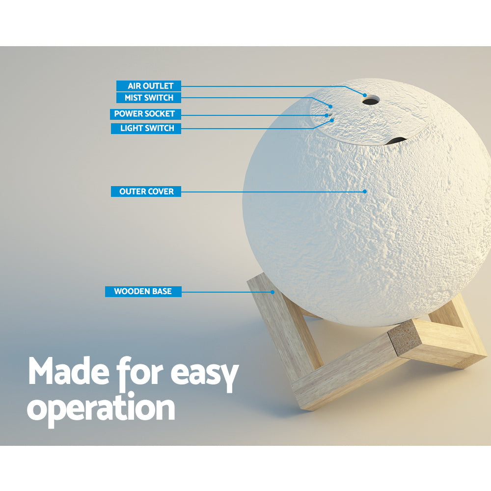 White LED moon lamp aroma diffuser resting on a wooden base with mist emitting from top — view 4