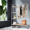 White powder-coated metal clothes rack with wooden storage shelves and anti-slip hanging bar