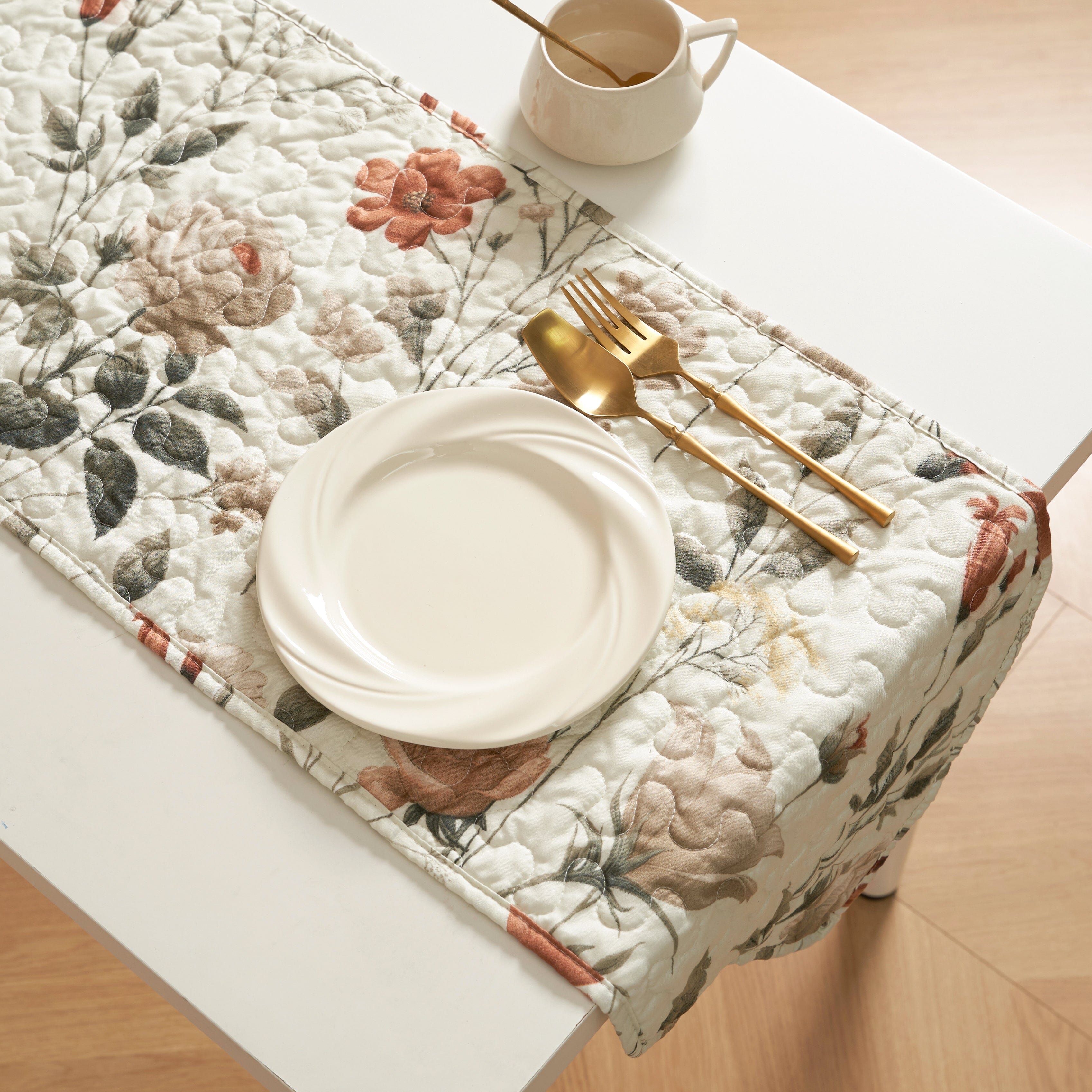 Reversible floral quilted table runner in beige and soft green for dining room tabletop protection
