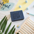 Charcoal face wash bar, round black solid facial soap for naturally detoxifying vegan skincare.