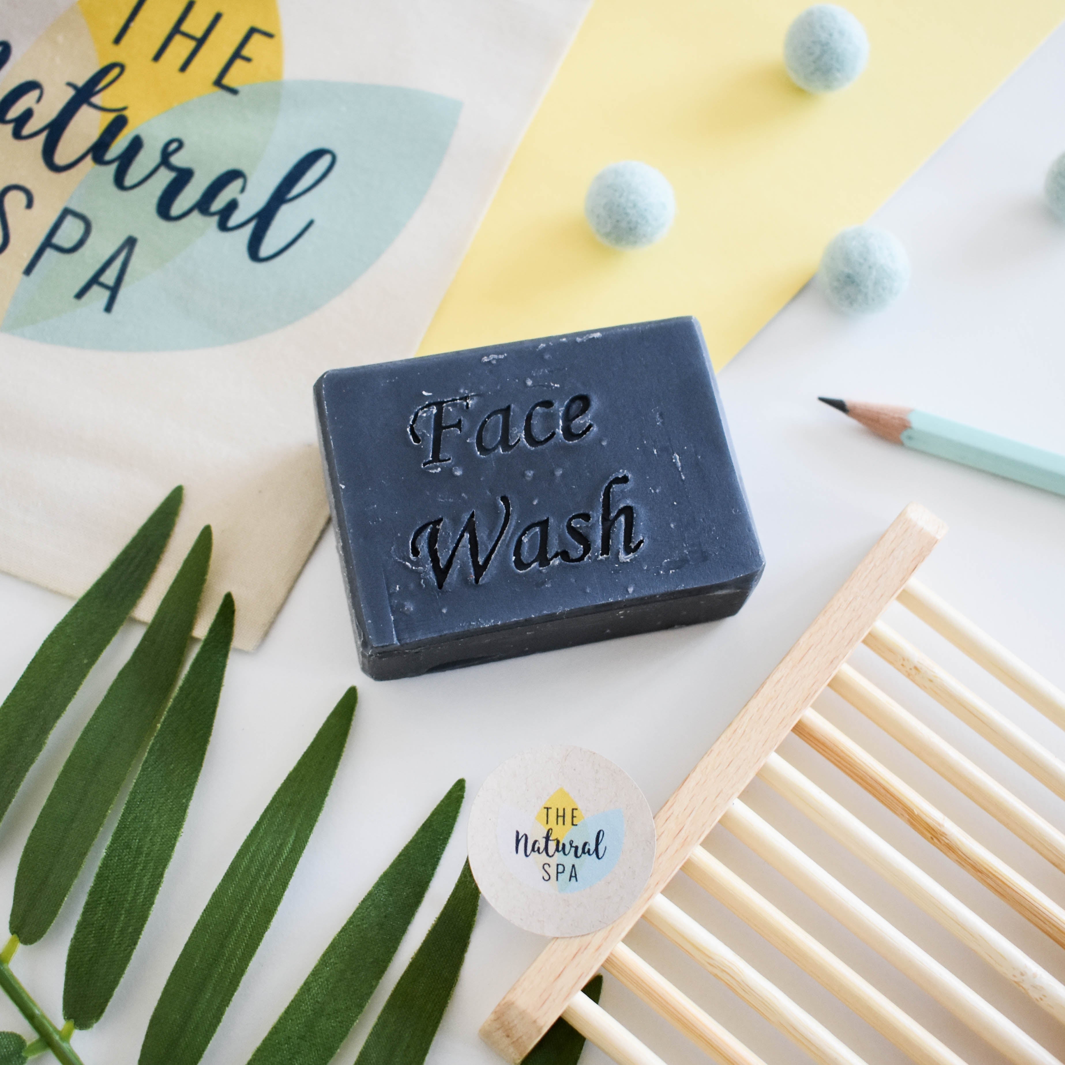 Charcoal face wash bar, round black solid facial soap for naturally detoxifying vegan skincare.