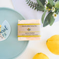 Lemon sorbet handmade natural soap bar with poppy seeds, showcasing a textured yellow botanical finish.
