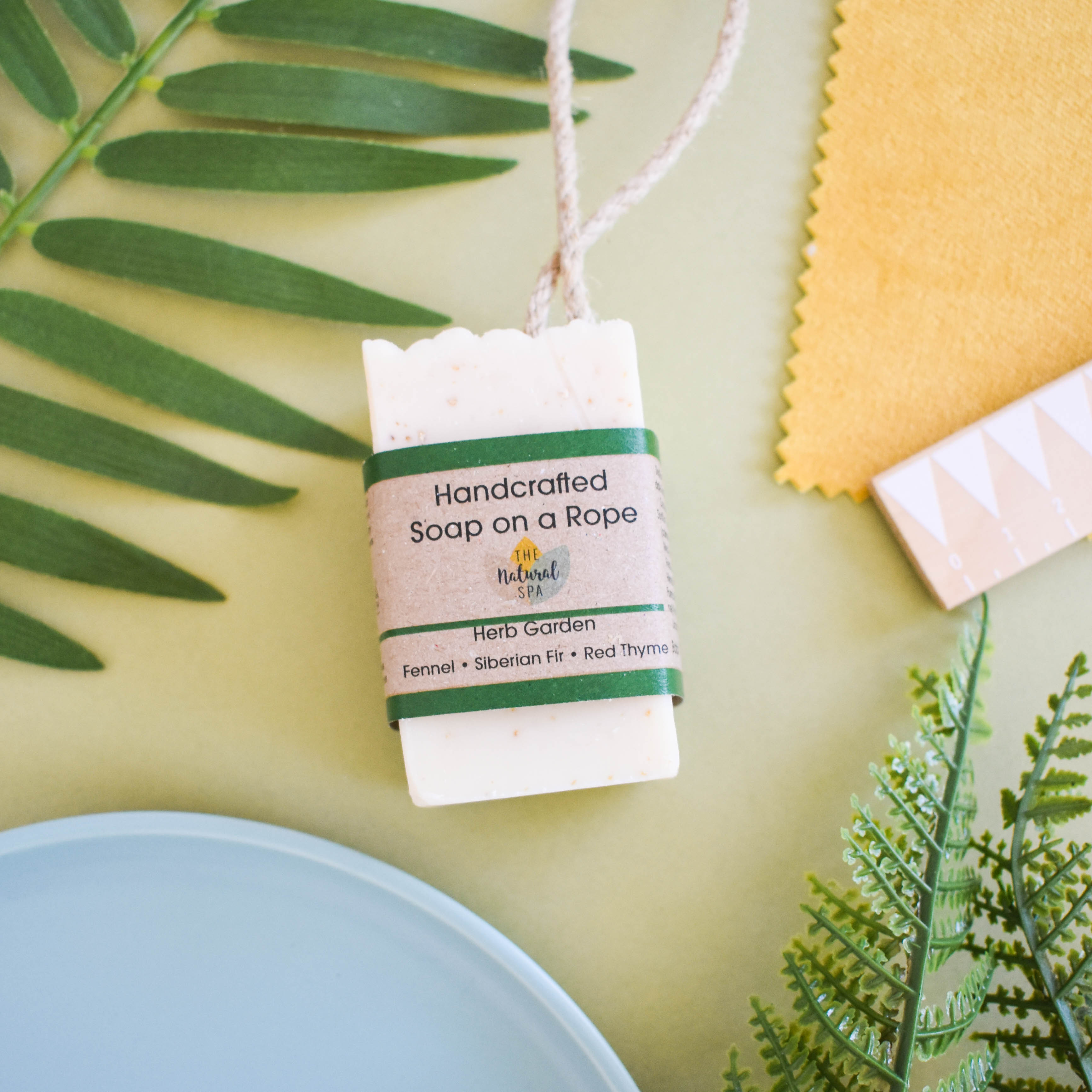 Rustic handcrafted herb garden soap on a cotton rope featuring natural exfoliating oats and clay