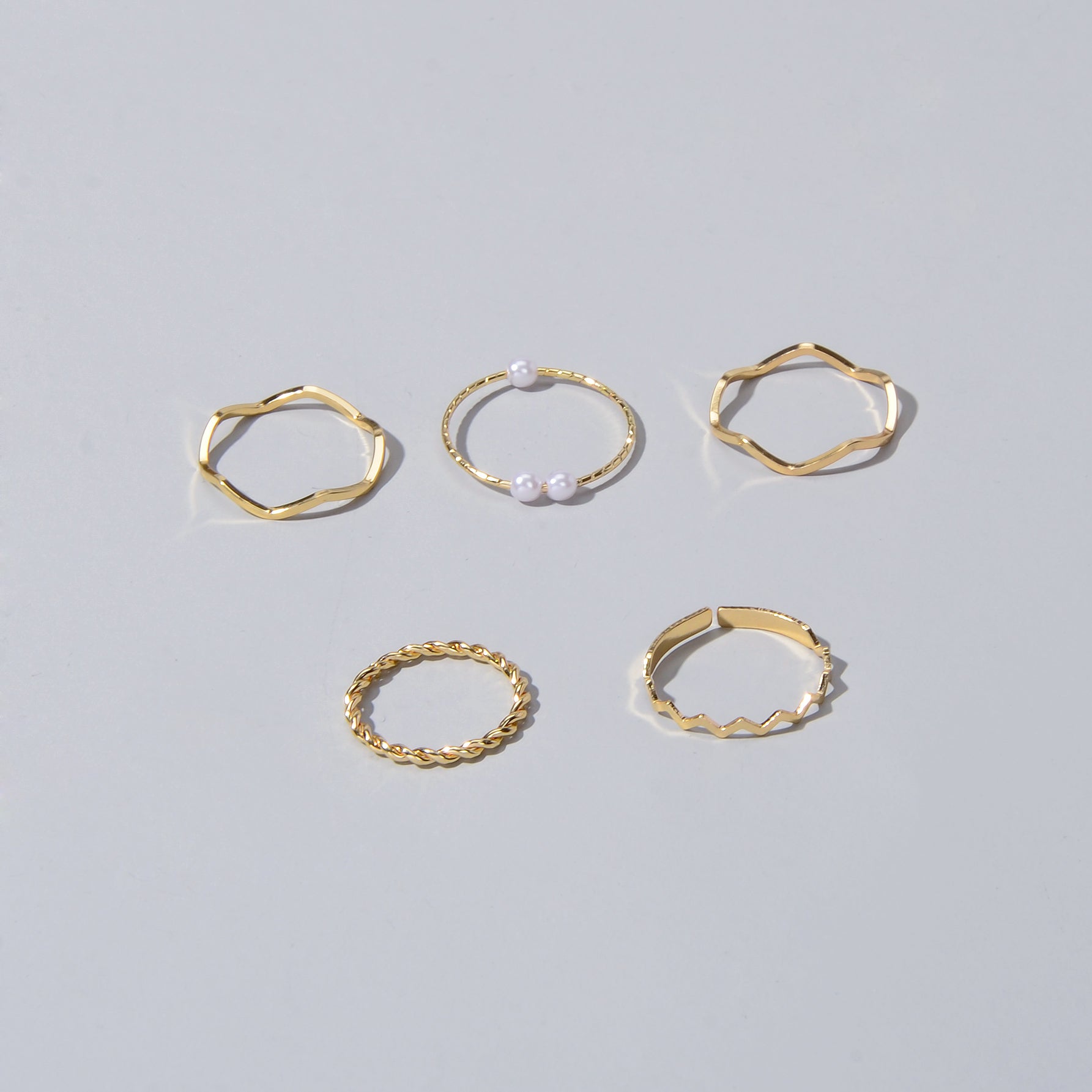 5 piece stackable minimalist finger ring set in metal with elegant pearl accents — view 2