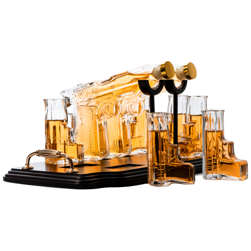Double pistol whiskey decanter set with six shot glasses on a wooden display stand