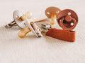 Soft silicone baby pacifier with fabric holder clip in natural earth tones for infants.