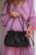 Etoile crossbody leather clutch bag in black genuine leather with braided strap and drawstring closure.