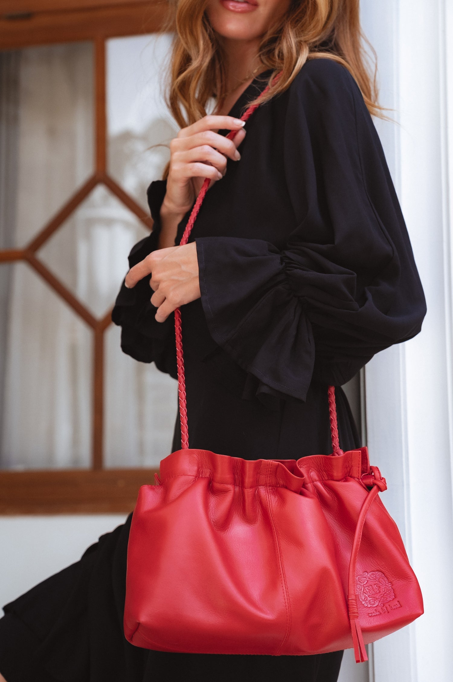 Red Etoile crossbody leather clutch bag with drawstring folds and a braided leather strap — view 2