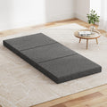 Dark grey folding foam single mattress convertible into a small sofa bed with textured fabric