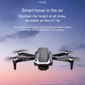Black folding 4K dual camera drone with remote control and propellers extended for flight