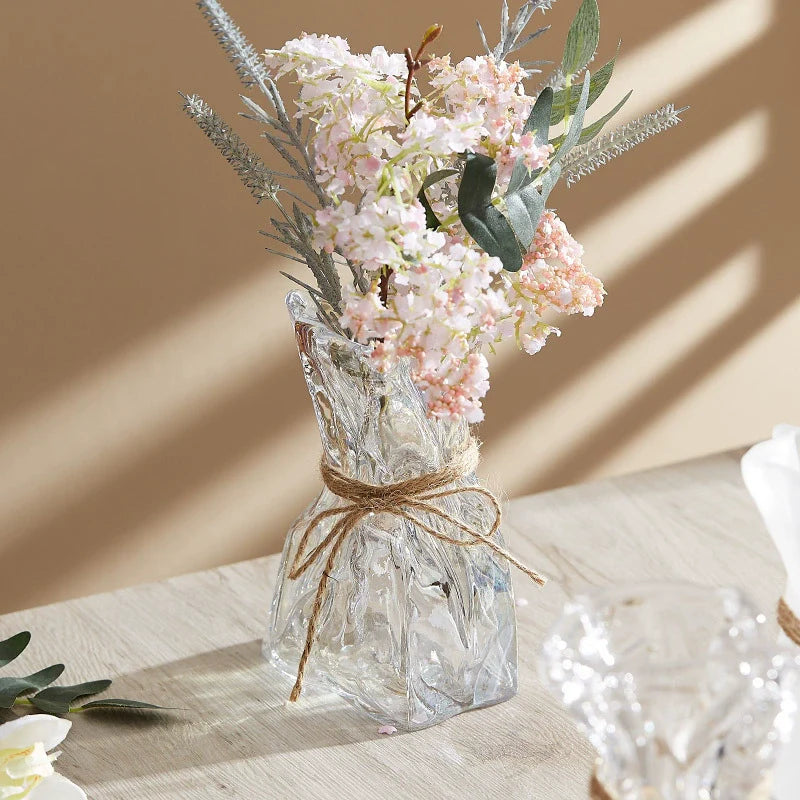 Wrinkled glass vase with natural twine accent and folded paper texture on a modern table — view 3