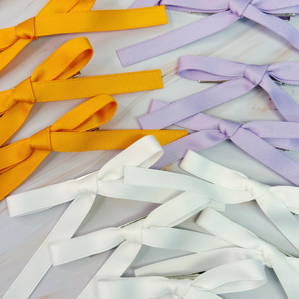 Set of five solid color bow hair clips arranged together, 5 inches wide with medium hold — view 2