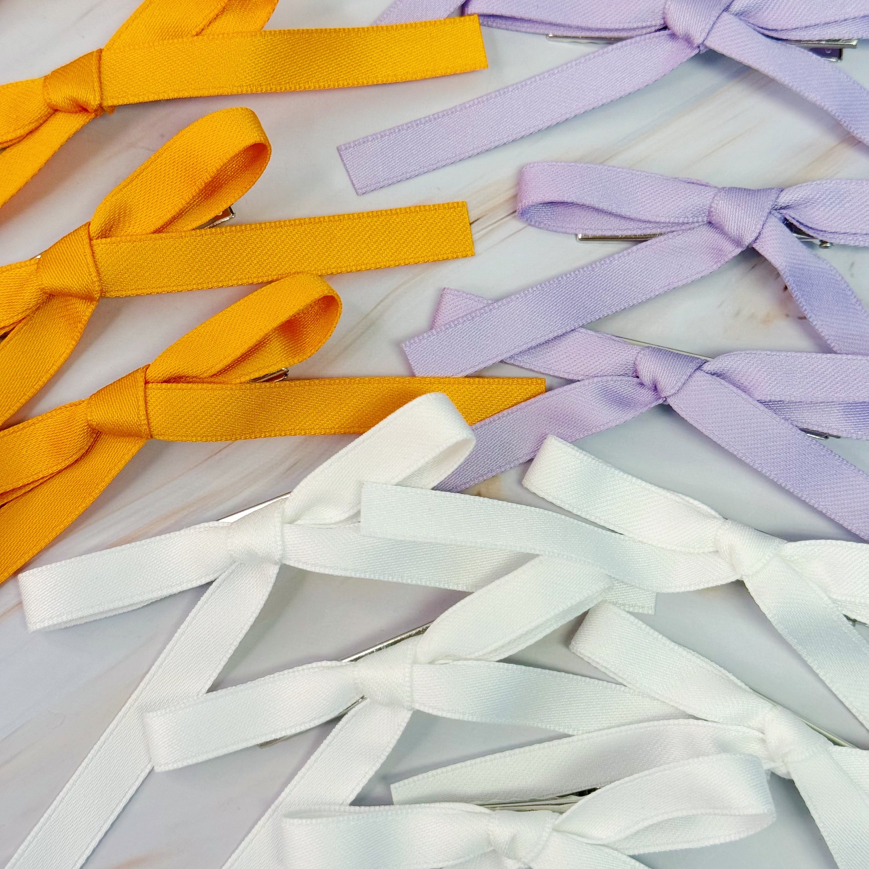 Set of five solid color bow hair clips arranged together, 5 inches wide with medium hold — view 2