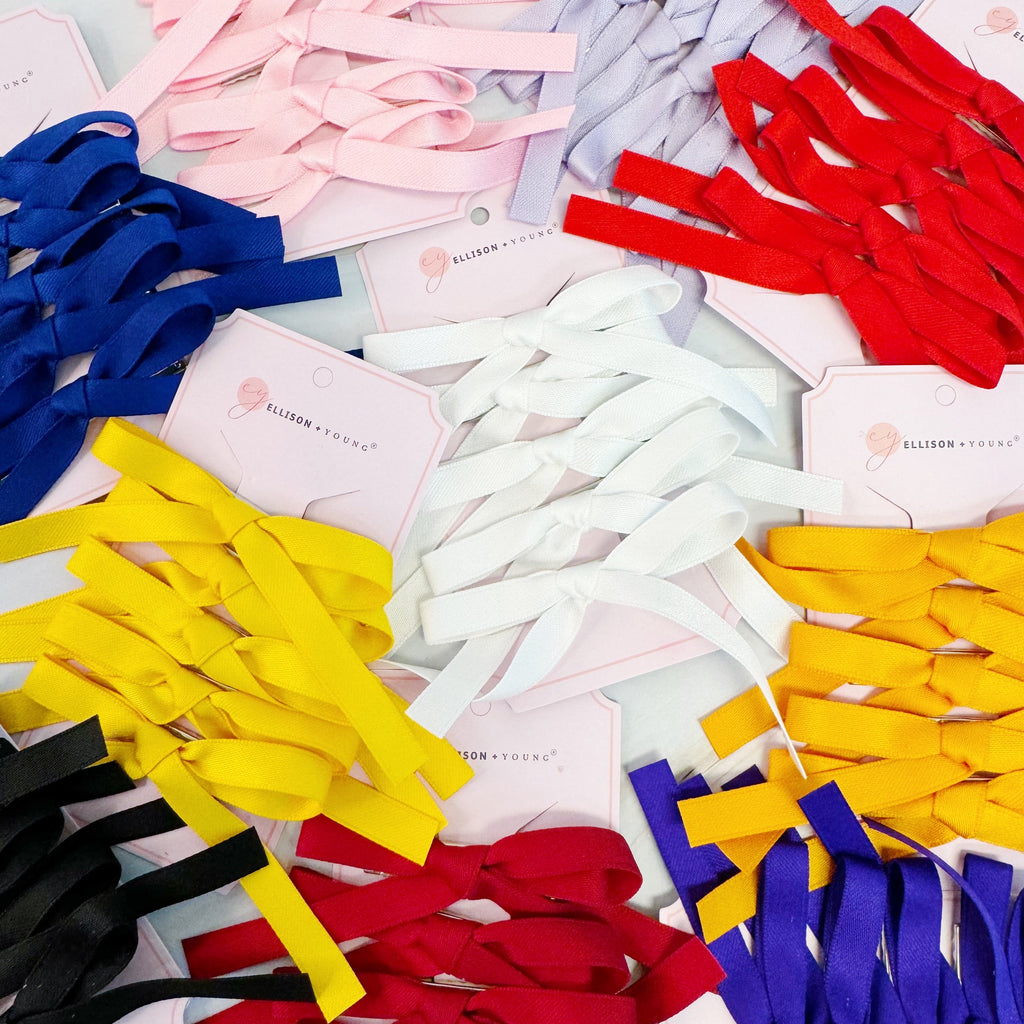 Set of five solid color bow hair clips arranged together, 5 inches wide with medium hold
