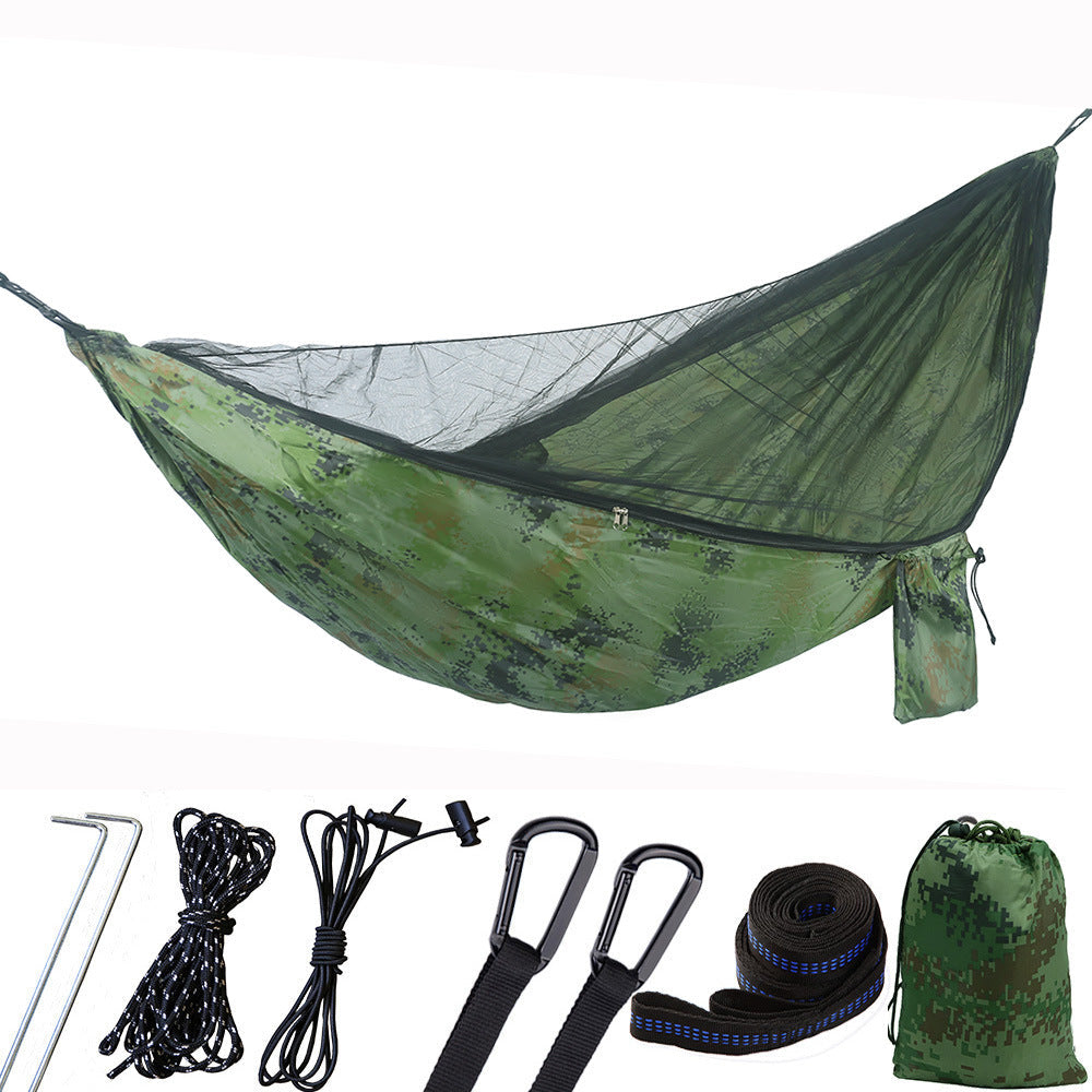 Portable camping hammock with openable mosquito net hanging between two trees outdoors — view 3