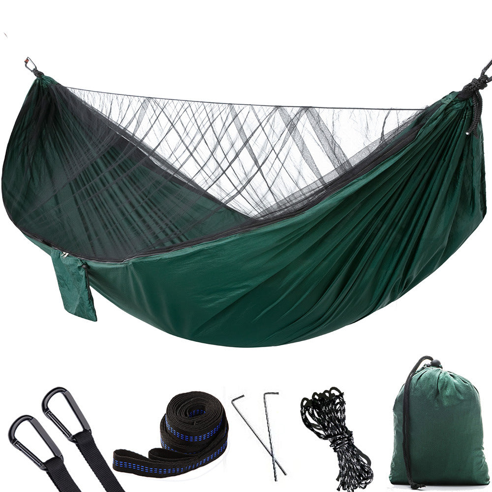 Portable camping hammock with openable mosquito net hanging between two trees outdoors — view 5