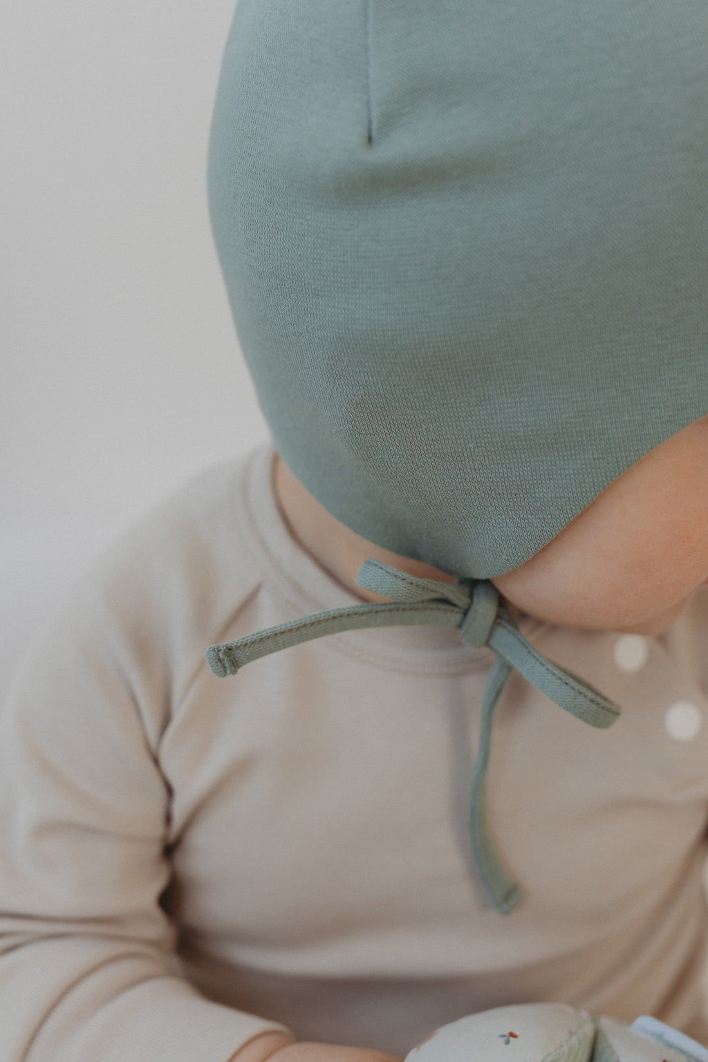 Ribbed cotton baby hat with secure chin ties and ear protection flaps for newborns. — view 2