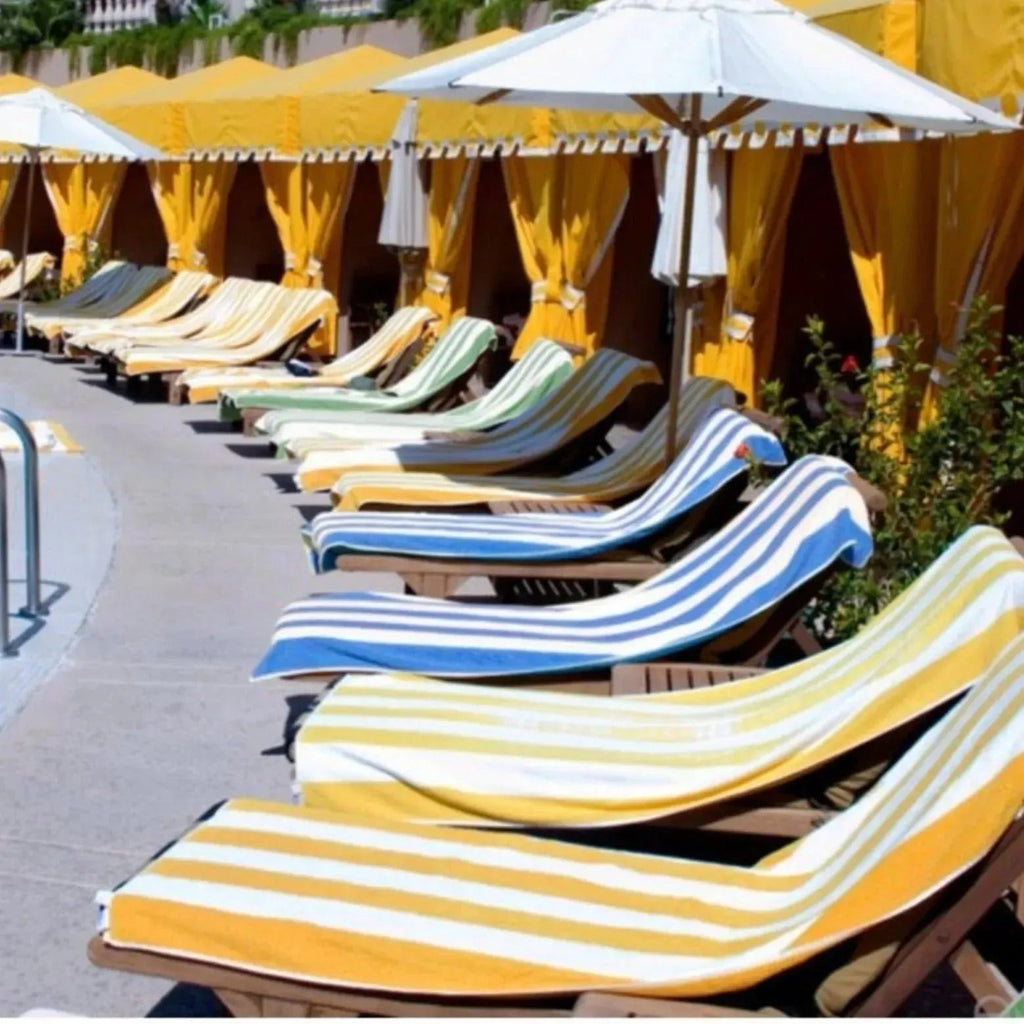 Cabana striped premium cotton pool and beach towels folded neatly in vibrant resort style colors