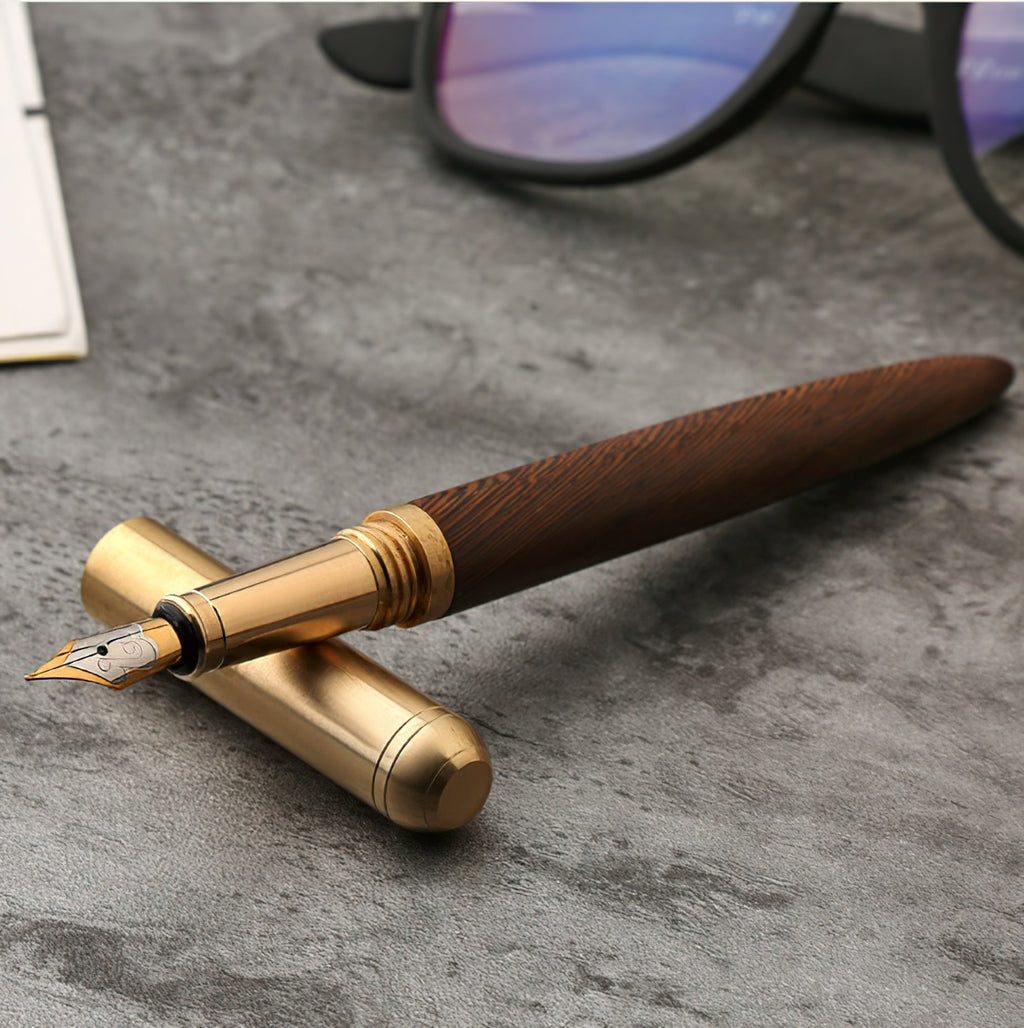 Handcrafted solid wood and brass fountain pen with a fine iridium nib on a desk