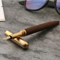Handcrafted solid wood and brass fountain pen with a fine iridium nib on a desk