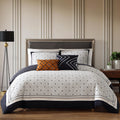 Black and white geometric reversible cotton comforter set with shams and decorative pillows on bed