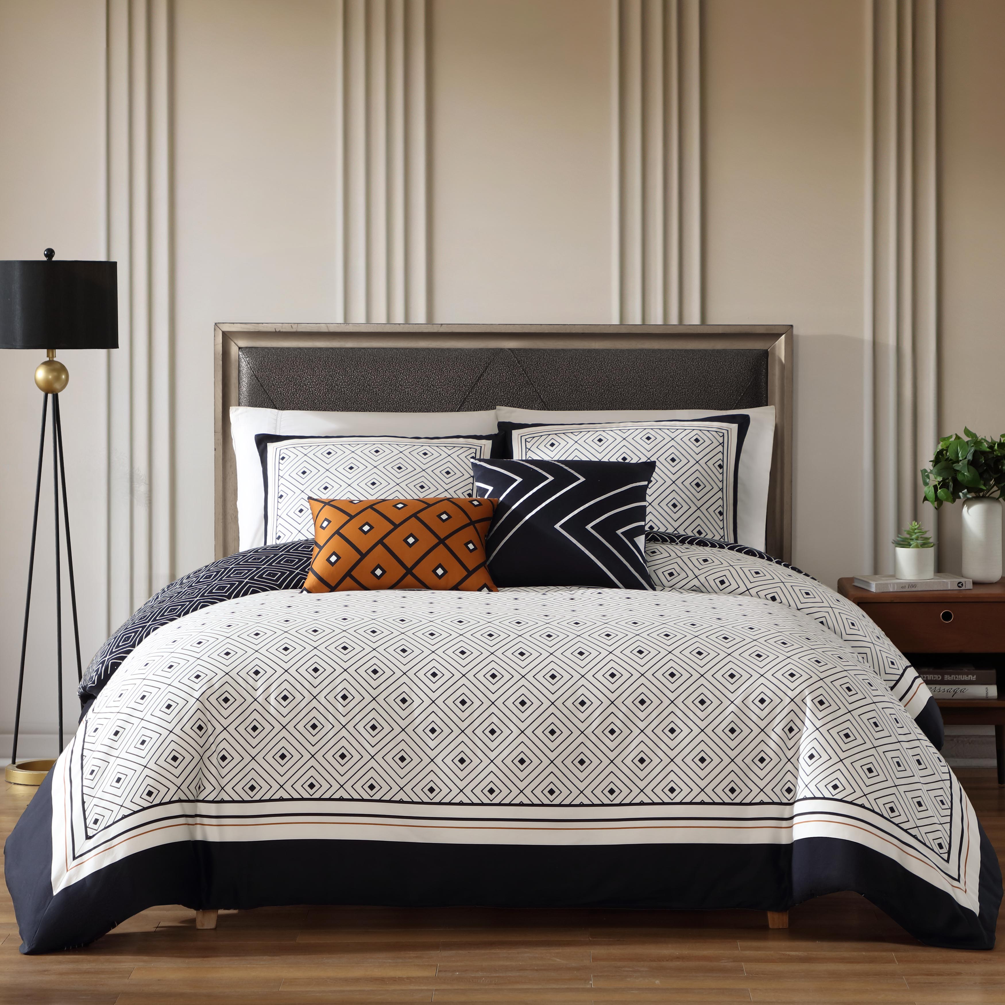 Black and white geometric reversible cotton comforter set with shams and decorative pillows on bed
