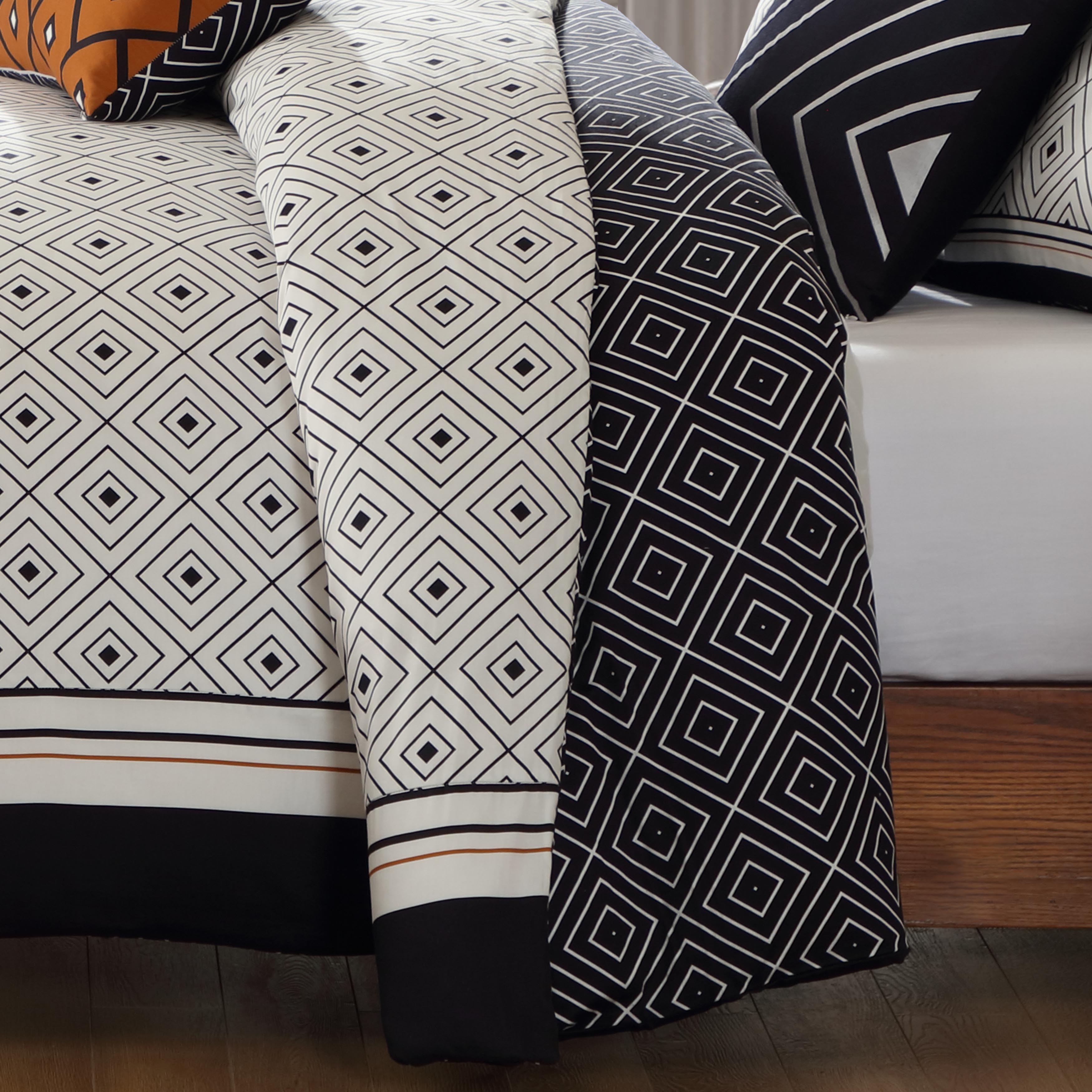 Black and white geometric reversible cotton comforter set with shams and decorative pillows on bed — view 4