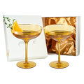 Sunset yellow coupe glasses with elegant gold rims and bubble texture for champagne and cocktails