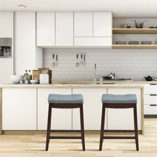 Set of two white backless counter stools featuring wooden legs nailhead trim and saddle seat — view 2