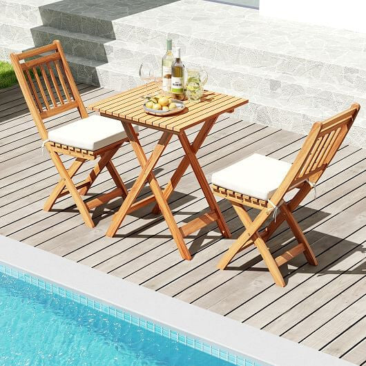 Acacia wood outdoor bistro set with folding table slatted chairs and soft white seat cushions — view 2