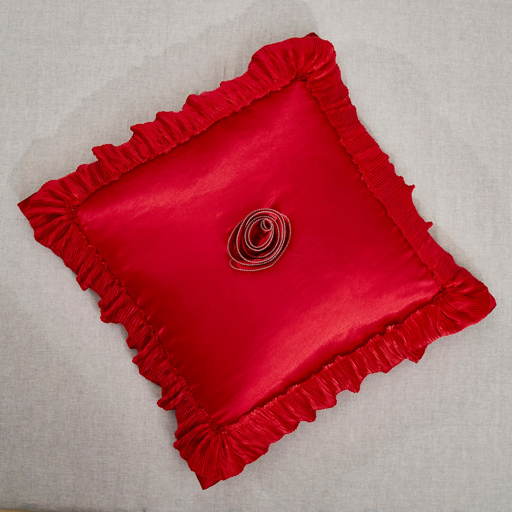 Bright red satin ruffled Euro pillow sham with floral embellishments and vintage ballroom design.