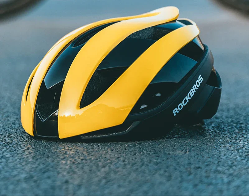 Ultralight yellow bicycle helmet with magnetic snap closure and aerodynamic ventilation vents for road cycling — view 3