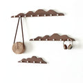 Wooden mountain shape wall hook rack with multiple foldable pegs mounted on a white wall