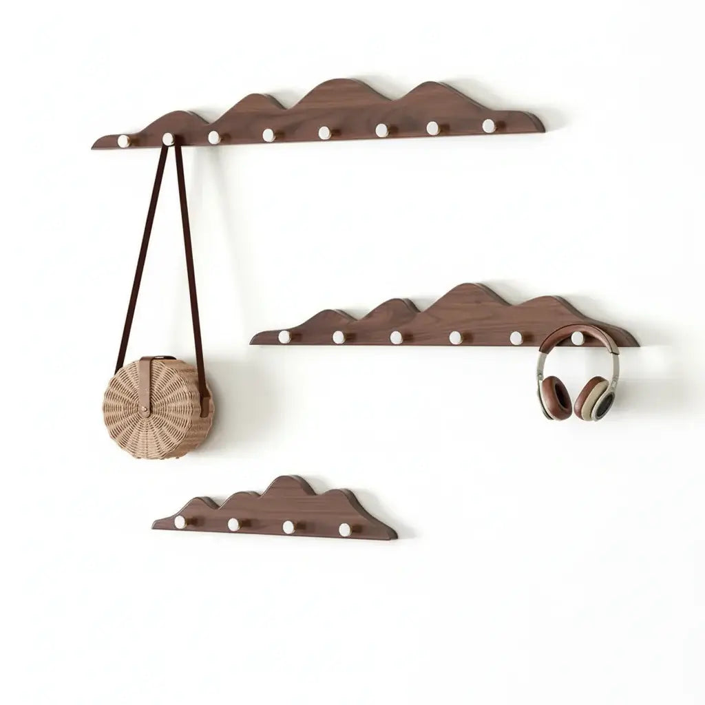Wooden mountain shape wall hook rack with multiple foldable pegs mounted on a white wall