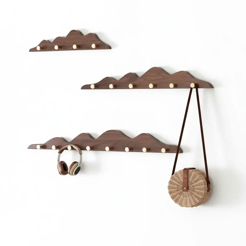 Wooden mountain shape wall hook rack with multiple foldable pegs mounted on a white wall — view 2