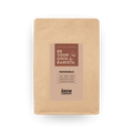 Whole Honduras coffee beans in eco-friendly kraft paper packaging on a table