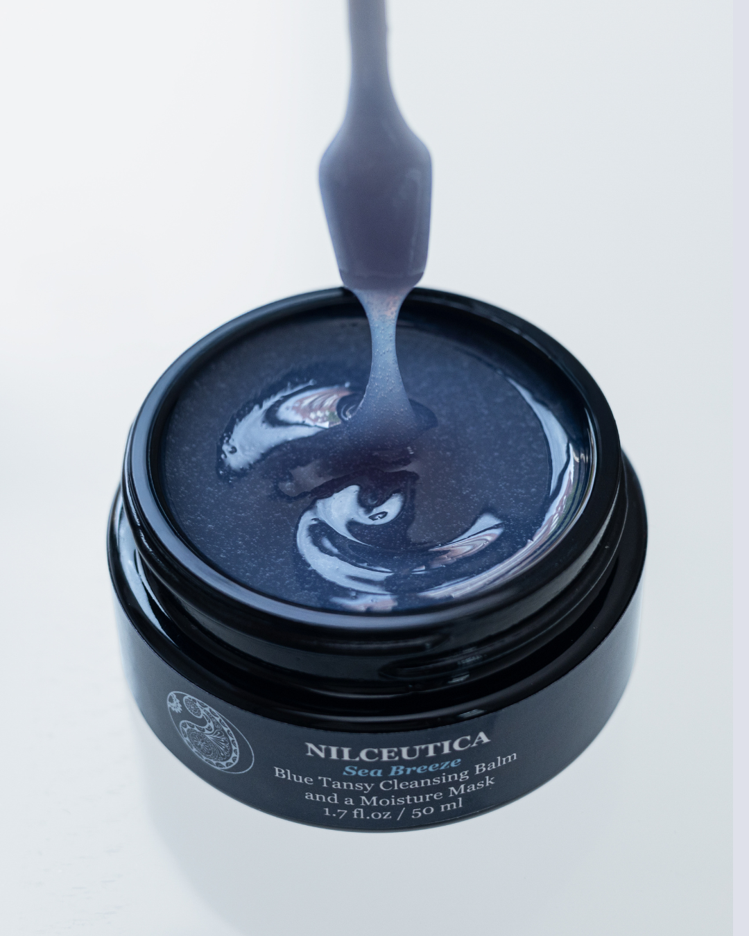 Blue tansy exfoliating cleansing balm and hydration mask in a premium glass jar.