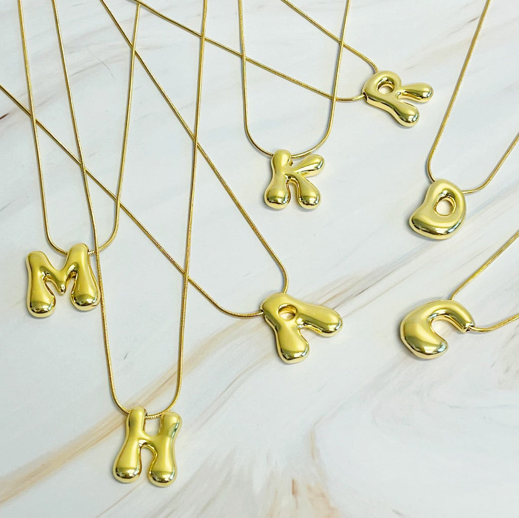 Gold plated balloon letter initial necklace with a stainless steel chain on a plain background — view 2