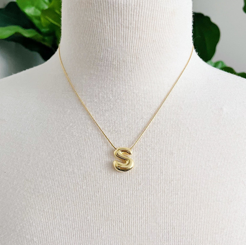Gold plated balloon letter initial necklace with a stainless steel chain on a plain background — view 4
