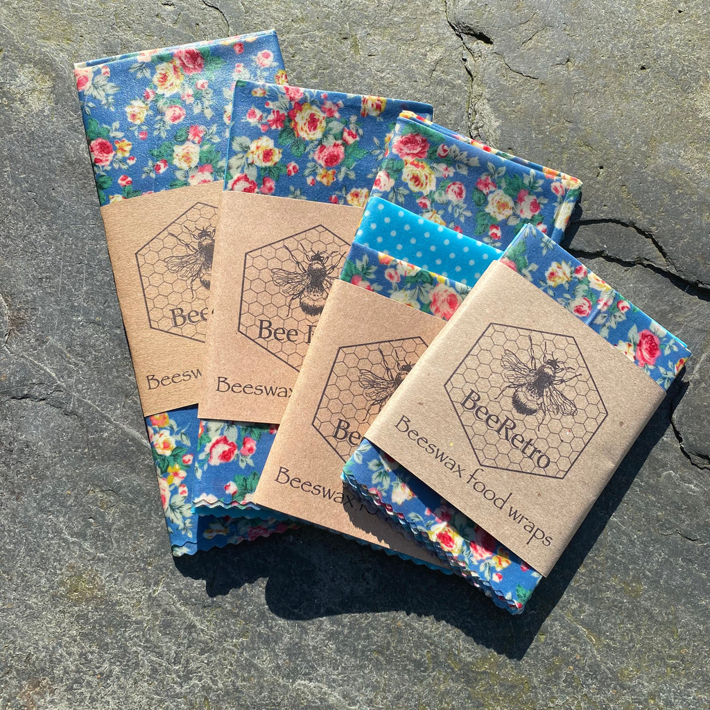 Blue chintz floral pattern reusable beeswax food wrap covering a bowl and wrapping a sandwich